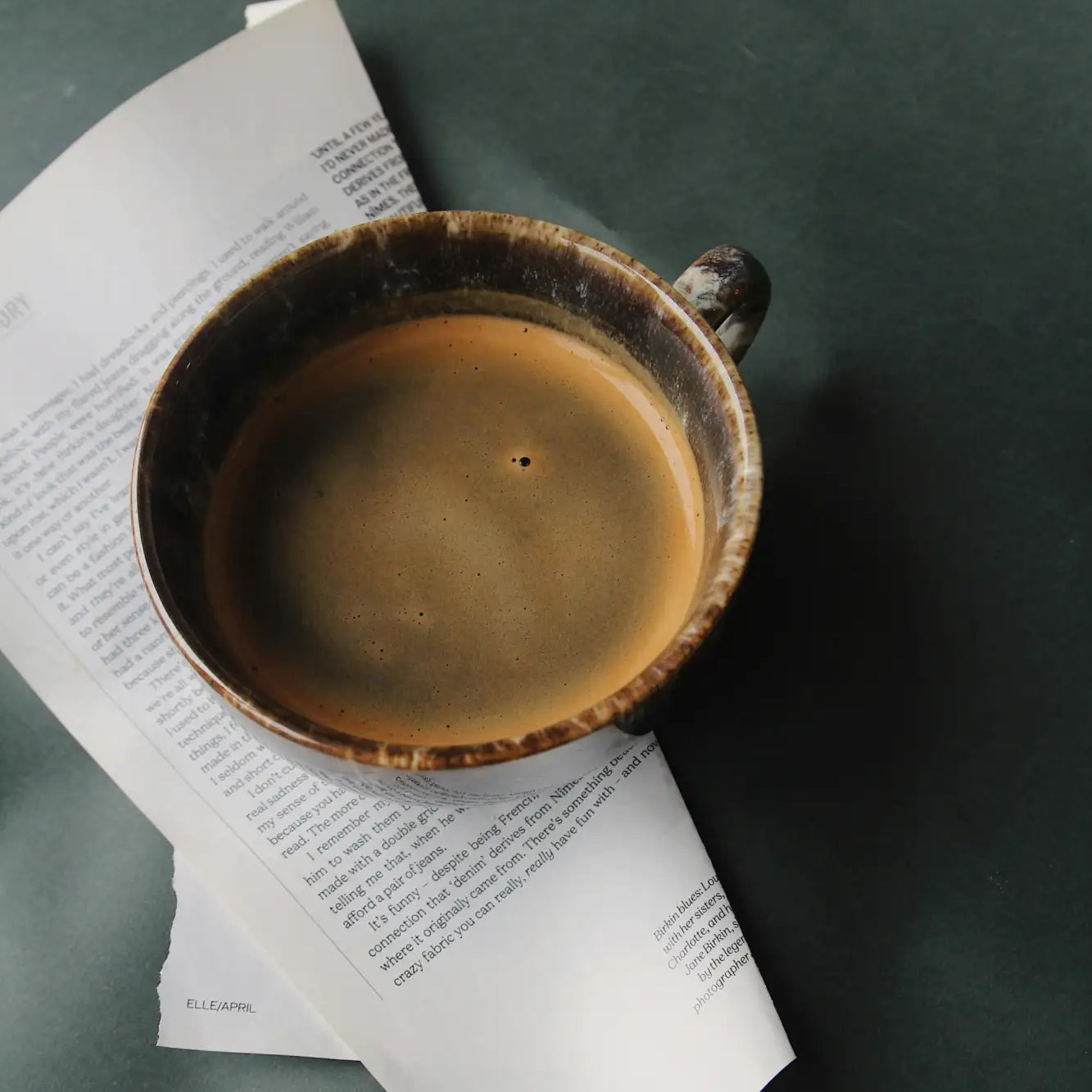 Earthenware coffee cup with a rustic, glazed finish and dark brown rim.