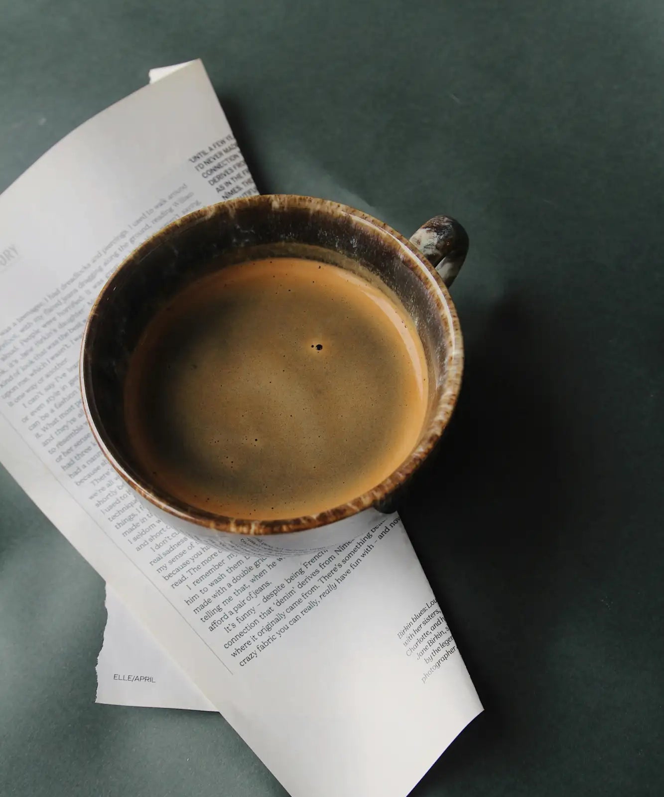 Earthenware coffee cup with a rustic, glazed finish and dark brown rim.